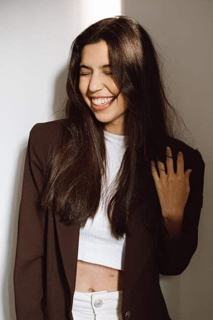 Style Evolution: How to Bring New Life to Your Wardrobe Smiling woman with long dark hair wearing a brown blazer and white top.