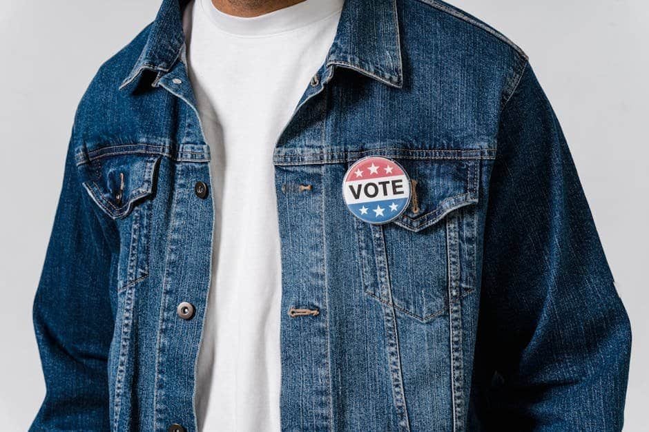 The Politics of Fashion: How Clothes Can Make a Statement Person wearing a denim jacket with a 'VOTE' badge for election support.