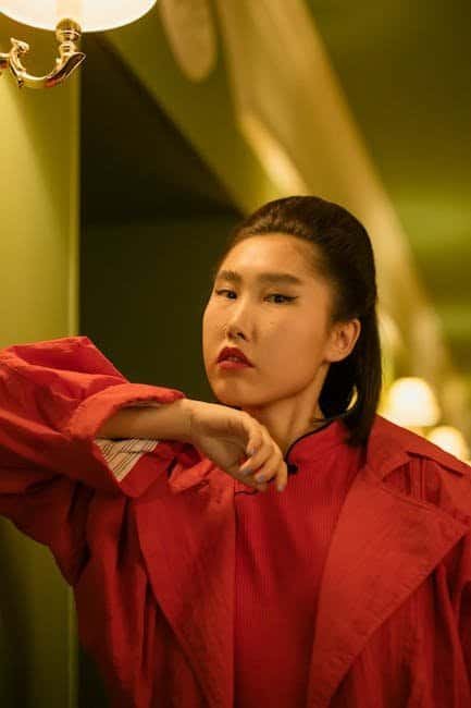 How to Stay Mentally Aware While Navigating Fashion Trends Stylish woman in red jacket posing indoors for The Cool Shirt.
