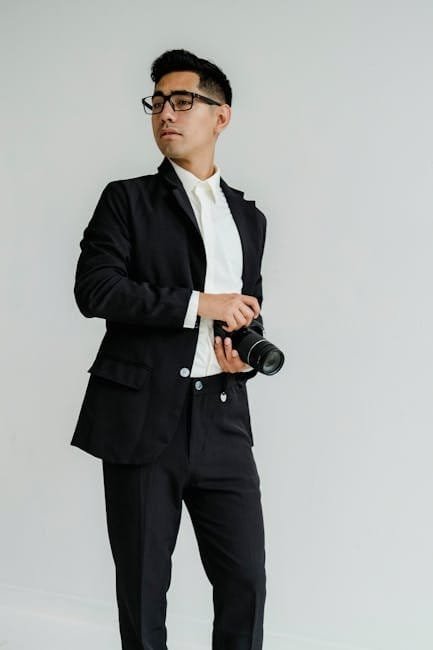 Professional man in suit holding camera, looking confident and stylish.
