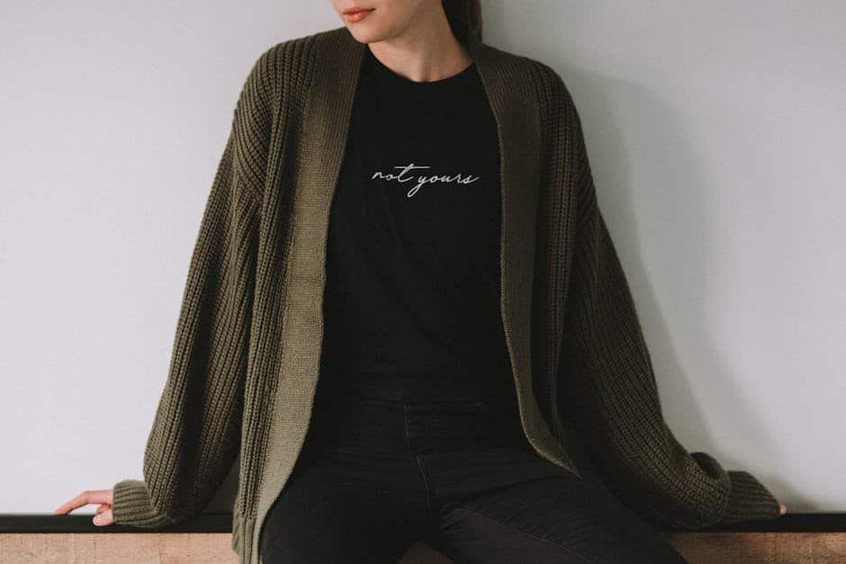 Woman in black T-shirt and oversized cardigan, casual fashion style.